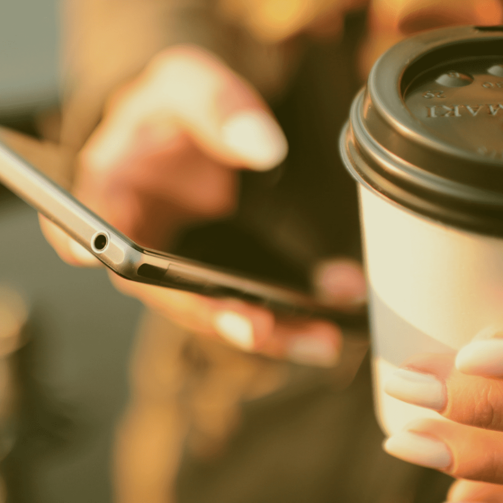 A woman holding a cellphone and a coffee for Talk to us section in homepage